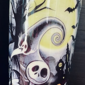 K&ouml;nnte beinhalten: Ein wei&szlig;er Becher mit einem Schwarzwei&szlig;bild von Jack Skellington aus Nightmare Before Christmas. Das Bild zeigt au&szlig;erdem einen Vollmond, Flederm&auml;use und ein Spukhaus.