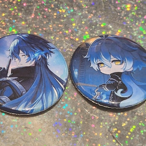 May include: Two round, blue and white anime-style character pinback buttons. One button features a character with blue hair and a finger to the lips gesture. The other button shows a chibi version of the same character.