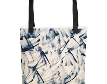 Puede incluir: Una bolsa de tela blanca con asas negras y un patrón abstracto azul y blanco. El patrón está formado por pinceladas y líneas.