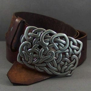 May include: A brown leather belt with a silver Celtic knot buckle.