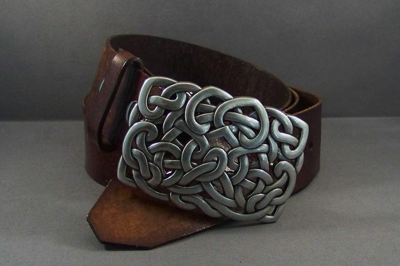 May include: A brown leather belt with a silver Celtic knot buckle.