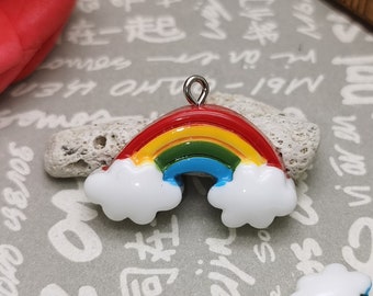 May include: Two rainbow charm pendants with white clouds. The charms are made of resin and have a silver loop for attaching to a necklace or bracelet.