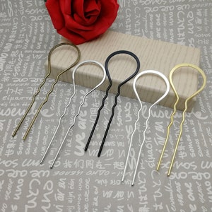 Puede incluir: Cuatro horquillas para el pelo en diferentes colores: dorado, plateado, negro y lat&oacute;n. Cada horquilla tiene un dise&ntilde;o ondulado y un bucle en la parte superior.