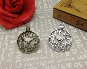 May include: Two antique-style clock charms, one silver and one bronze, with Roman numeral faces and openwork designs. The charms are on a white background with text.