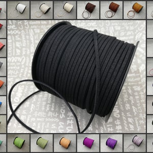 Puede incluir: Un carrete de cordón de ante negro, con una vista de cerca que resalta la textura y los detalles. Alrededor de la imagen principal hay carretes más pequeños de varios colores, incluyendo rojo, blanco y azul, ofreciendo una gama de opciones para proyectos de manualidades.