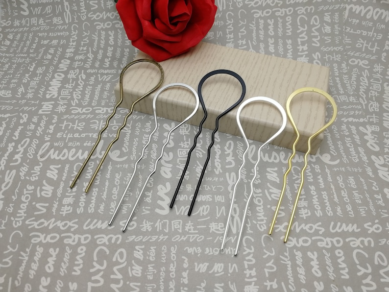 Puede incluir: Cuatro horquillas para el pelo en diferentes colores: dorado, plateado, negro y lat&oacute;n. Cada horquilla tiene un dise&ntilde;o ondulado y un bucle en la parte superior.