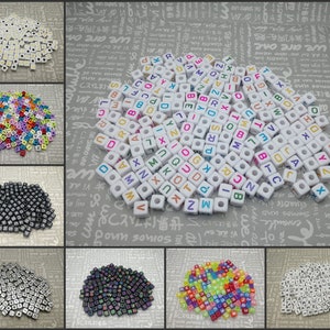 May include: Assortment of letter beads in various colours, including white, black, silver, and rainbow. The beads are made of plastic and have a square shape. Each bead has a letter printed on it.