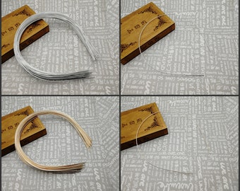 Può includere: Un set di quattro cerchietti per capelli in filo d'argento e oro. I cerchietti sono sottili e flessibili e sono disposti in una pila su uno sfondo bianco.
