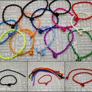 May include: Assortment of colorful braided rope bracelets with knotted closures. The bracelets are made of different colors, including red, green, blue, yellow, and purple.