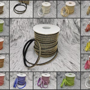 Può includere: Una varietà di passamanerie con strass in diversi colori, tra cui nero, bianco, oro, rosso, blu, verde e rosa. La passamaneria è mostrata su bobine ed è perfetta per aggiungere un tocco di brillantezza a qualsiasi progetto.