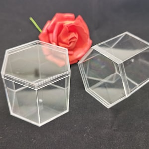 Puede incluir: Dos cajas hexagonales de plástico transparente. Las cajas están vacías y tienen un aspecto ligeramente esmerilado.