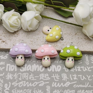 May include: Mushroom-shaped charms in pastel shades of lavender, pink, and green. Each charm features a white stem and a smiling face. A yellow mushroom charm and white roses are also visible.