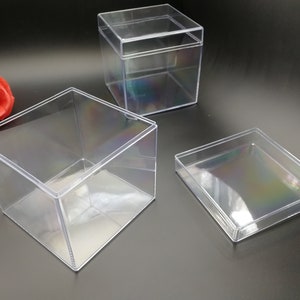 Puede incluir: Tres cajas de plástico transparente de diferentes tamaños. Las cajas son de forma cuadrada y rectangular. Las cajas están hechas de plástico transparente y tienen un ligero brillo iridiscente.