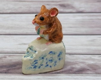 Cheeky little Mouse sitting on Stilton cheese