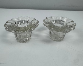 Juego de 2 portavelas cónicos de cristal transparente vintage con forma de pétalos de flores festoneados.