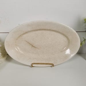 May include: A white ceramic mug with a black handle and the text "But First, Coffee" in a bold, black font. The mug is set against a blurred background, suggesting a cozy setting. The mug appears to be approximately 4 inches tall.