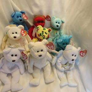 Puede incluir: Colecci&oacute;n de peluches Beanie Baby en varios colores, incluyendo azul, blanco y rojo. Algunos tienen alas de &aacute;ngel y halos. Cada juguete tiene una etiqueta en forma de coraz&oacute;n Ty.