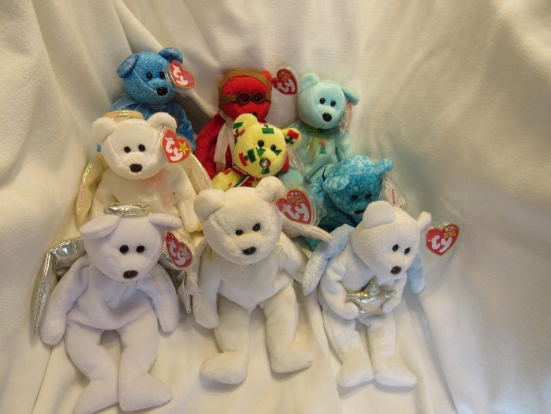 Puede incluir: Colecci&oacute;n de peluches Beanie Baby en varios colores, incluyendo azul, blanco y rojo. Algunos tienen alas de &aacute;ngel y halos. Cada juguete tiene una etiqueta en forma de coraz&oacute;n Ty.