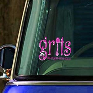 May include: A blue car with a pink sticker that says "Grits" with a spoon and fork design. The text below the logo says "Girls Raised in the South".