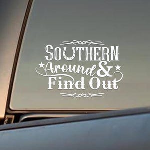 May include: White vinyl decal with the text "Southern Around & Find Out" on a black truck window. The text is stylized with a horseshoe and stars.