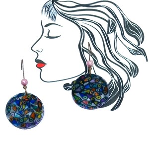 Peut inclure: Une paire de boucles d'oreilles pendantes avec un motif rond, coloré et abstrait. Les boucles d'oreilles sont en pâte polymère et ont un crochet argenté.