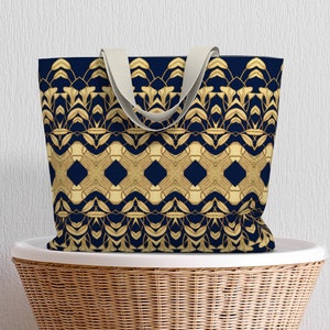 May include: A navy blue tote bag with a gold geometric pattern. The pattern features a repeating design of leaves and diamonds.
