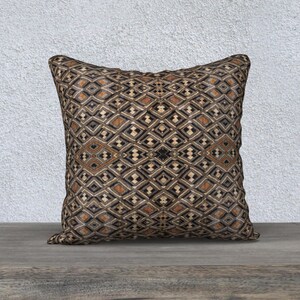 May include: A decorative throw pillow with a geometric pattern in shades of brown, black, and white. The pillow has a square shape and a soft, plush texture.