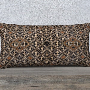 May include: A rectangular throw pillow with a geometric pattern in shades of brown, black, and white. The pattern features a repeating diamond shape.