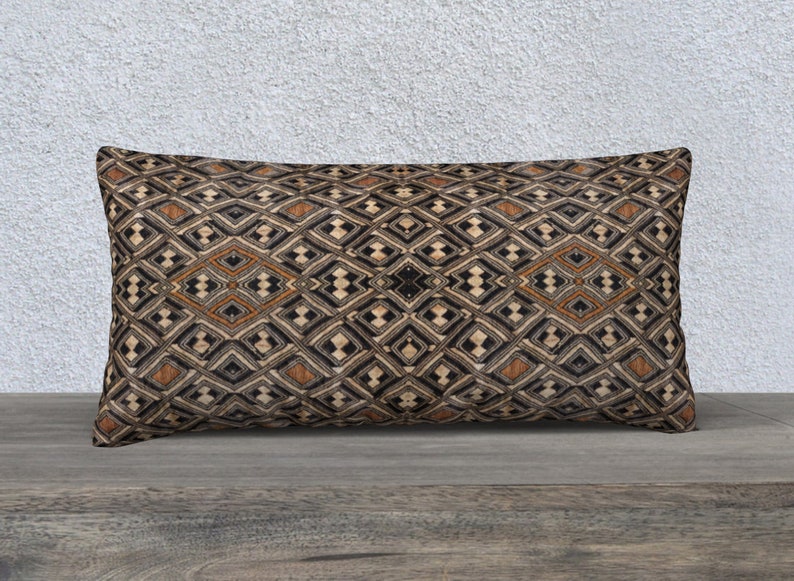 May include: A rectangular throw pillow with a geometric pattern in shades of brown, black, and white. The pattern features a repeating diamond shape.