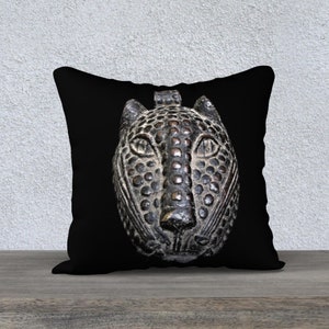 May include: Black and brown throw pillow with a detailed image of a leopard's face.