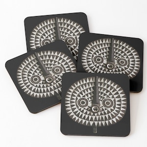 May include: Set of four black coasters with a white and gray geometric design. The design features a circular pattern with a central vertical line and two circles.