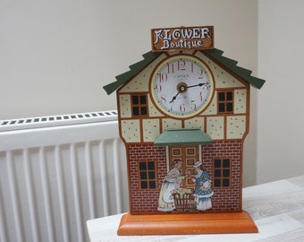 Vintage wall clock by Captain Clock Co, mechanical wooden house shop shape watch working battery operated city town scene Victorian style