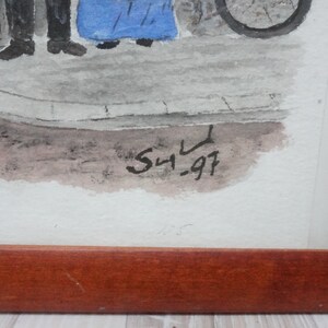 May include: Watercolor painting in a wooden frame. The artwork depicts figures on a street with a bicycle wheel visible. The painting is signed "S4.97" in black ink. The frame is a dark brown color.