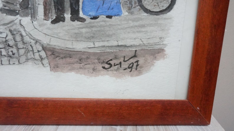 May include: Watercolor painting in a wooden frame. The artwork depicts figures on a street with a bicycle wheel visible. The painting is signed "S4.97" in black ink. The frame is a dark brown color.
