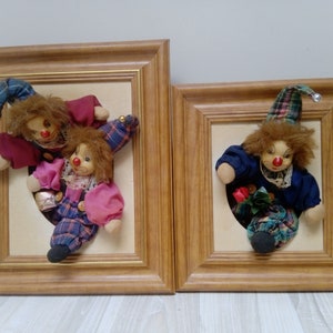 Puede incluir: Dos imágenes enmarcadas de payasos. La primera imagen presenta dos payasos, uno con un atuendo rojo y azul y el otro con un atuendo rosa y azul. La segunda imagen presenta un payaso con un atuendo azul y verde.