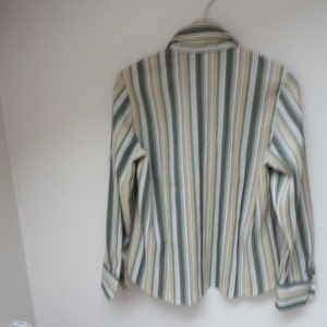 Puede incluir: Una camisa de manga larga a rayas con rayas verdes, amarillas y blancas.