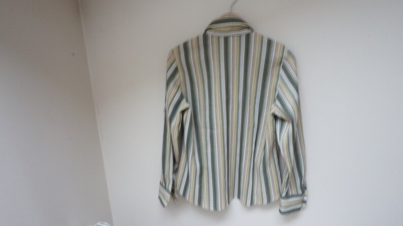 Puede incluir: Una camisa de manga larga a rayas con rayas verdes, amarillas y blancas.