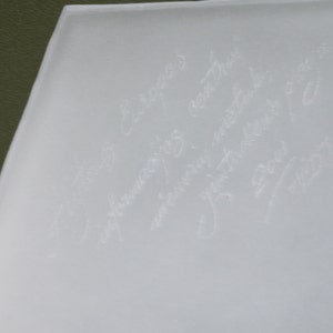 May include: A white frosted glass surface with several handwritten messages in white ink.