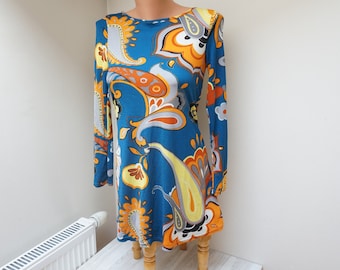 Könnte beinhalten: Ein langärmeliges Kleid mit Paisley-Muster in Blau, Orange und Gelb.