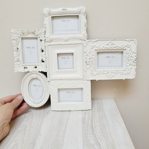 Puede incluir: Conjunto de marcos de fotos blancos con detalles ornamentados. Los marcos están dispuestos en forma de cruz y tienen una estética vintage. Cada marco tiene una pequeña etiqueta con el texto "Bella Luce" y las palabras "Photo Gallery".