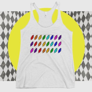 May include: A white racerback tank top featuring a pattern of colorful lightning bolt designs. The bolts are arranged in rows and include shades of red, orange, yellow, green, blue, and purple. The tank top has a scoop neck and a sleeveless design.