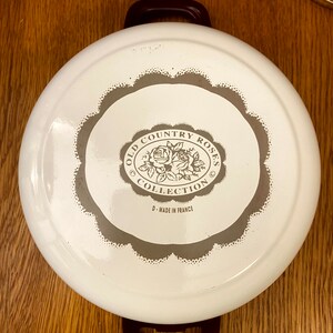 May include: White enamel pot with brown handles and a brown and white logo that reads "Old Country Roses Collection" and "D-Made in France".
