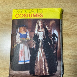May include: McCall's Costumes sewing pattern for a medieval costume. The pattern includes two costumes: a black and gold gown with a white underdress and a blue and white dress with a white apron. The pattern number is 2242.