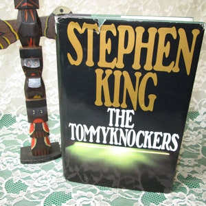 May include: A hardcover book with a black cover and gold lettering. The title is "Stephen King The Tommyknockers".