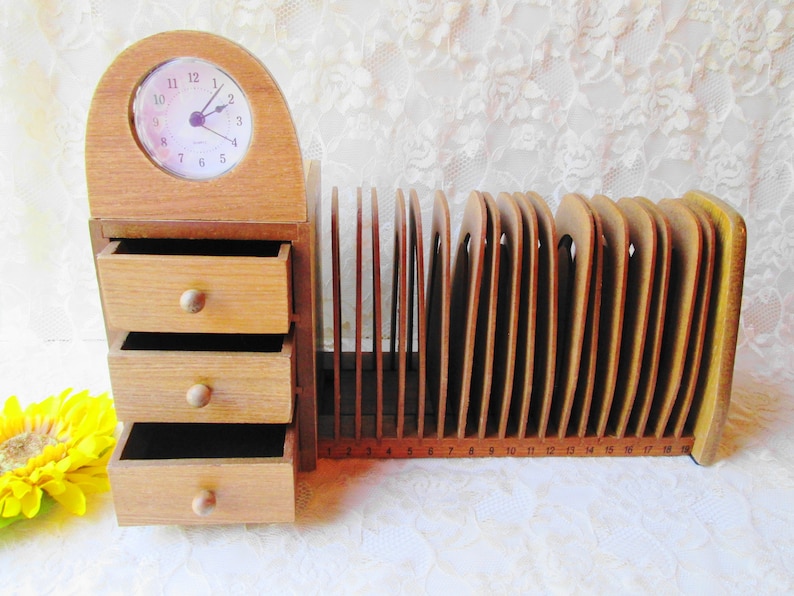 May include: Wooden desk organizer with three drawers and a clock on top. The organizer has a built-in letter holder with numbered slots.