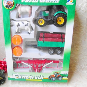 May include: A Farm World toy set with a green and black tractor, a trailer with logs, and toy farm animals. The set includes a cow, a sheep, and two orange hay bales. The packaging is green and white. The set is part of the Farm Truck series.