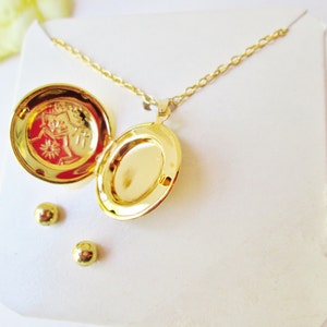 May include: Gold locket necklace with a small engraved design on the inside of the locket. The necklace comes with a pair of matching gold stud earrings.