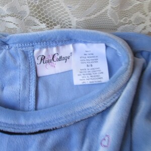 May include: A light blue velvet dress with a Rose Cottage tag. The tag says "Style #1478, 100% Polyester, 5/5, Made in China, See reverse for care instructions".