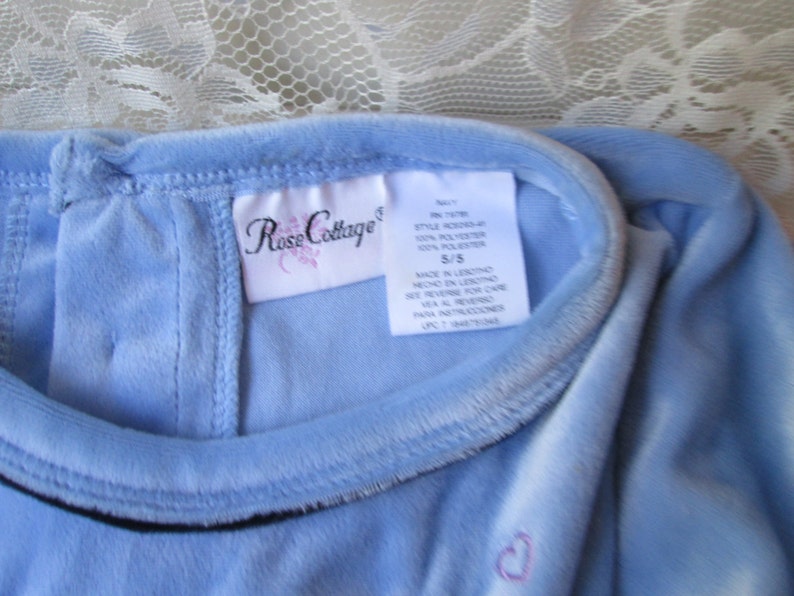 May include: A light blue velvet dress with a Rose Cottage tag. The tag says "Style #1478, 100% Polyester, 5/5, Made in China, See reverse for care instructions".