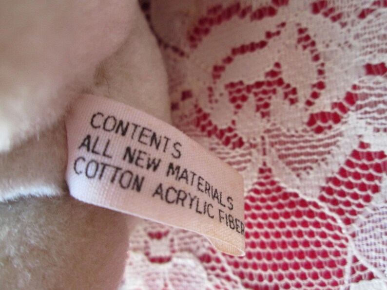 Może przedstawiać: Zbliżenie na białą etykietę z czarnym tekstem, kt&oacute;ry brzmi "Contents All New Materials Cotton Acrylic Fiber".